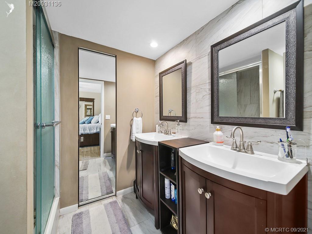 5804 Southeast Windsong Lane Stuart, FL 34997 - Photo 10 of 20 a bathroom with a sink and a mirror