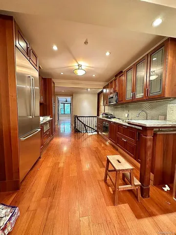 a kitchen with stainless steel appliances granite countertop a refrigerator a sink and a stove