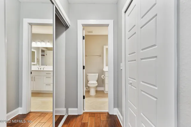 a bathroom with a toilet a sink a mirror a shower a vanity and window