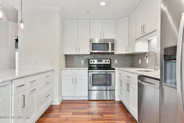 a kitchen with stainless steel appliances a refrigerator and a stove top oven