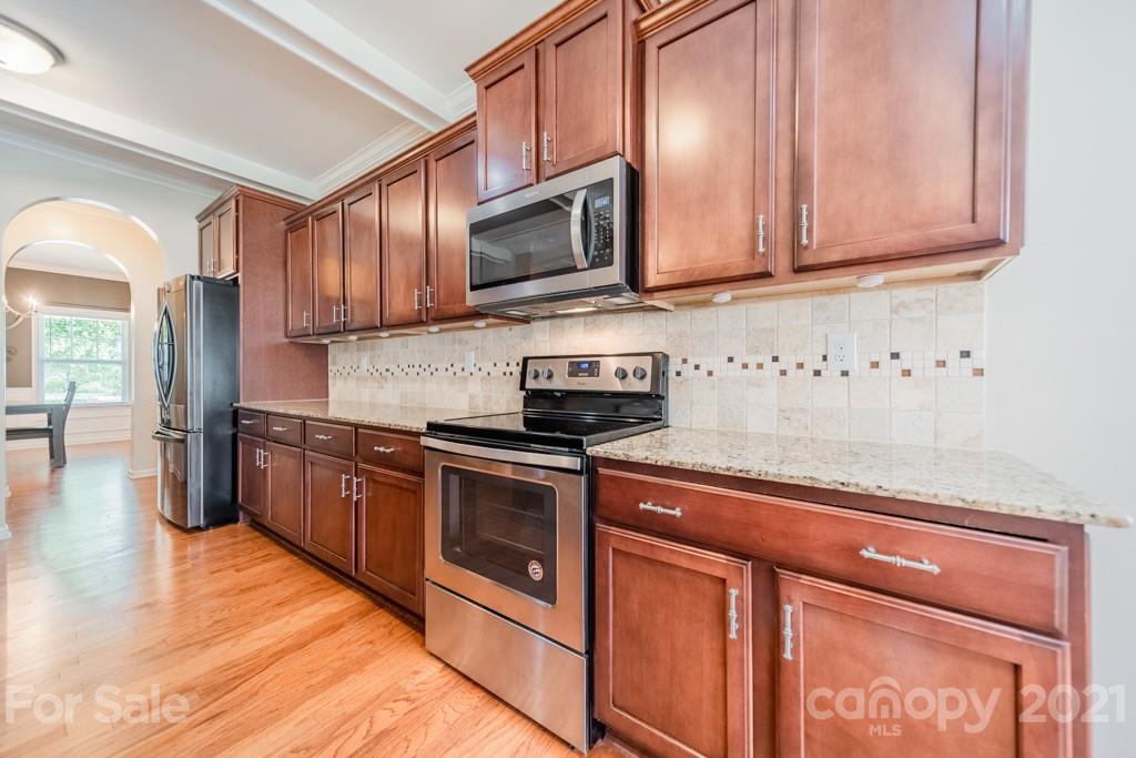 7062 Meyer Road Fort Mill, SC 29715 - Photo 11 of 46 a kitchen with stainless steel appliances granite countertop a stove a sink dishwasher and a microwave oven with cabinets