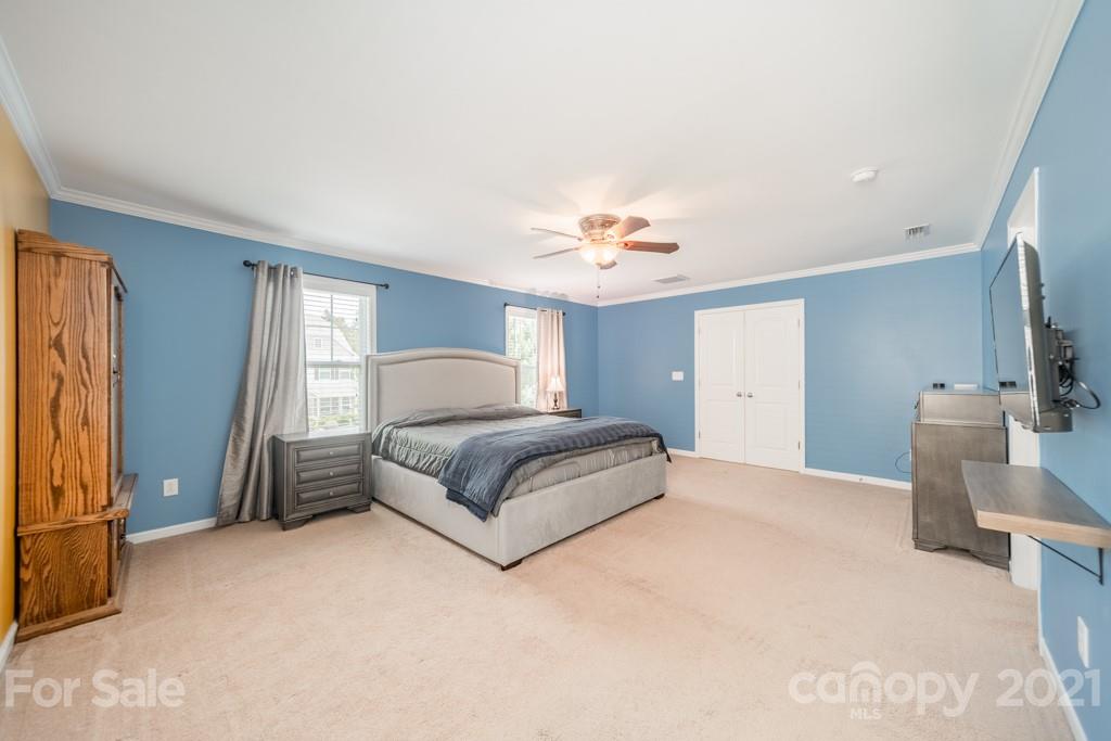7062 Meyer Road Fort Mill, SC 29715 - Photo 30 of 46 a spacious bedroom with a bed and a chandelier