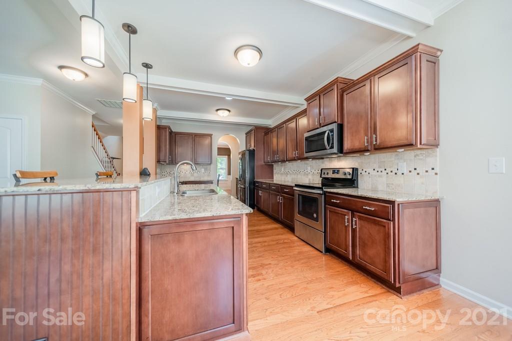 7062 Meyer Road Fort Mill, SC 29715 - Photo 9 of 46 a kitchen with stainless steel appliances granite countertop a stove sink and cabinets