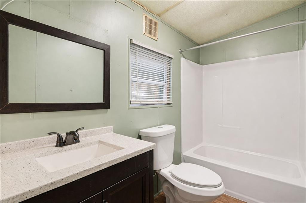 1344 Brookhaven Lane Blue Ridge, GA 30513 - Photo 8 of 17 a bathroom with a sink a toilet a mirror and shower