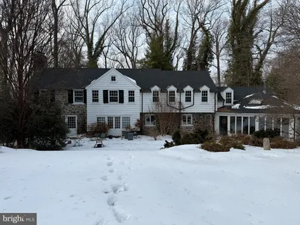 a front view of a house with a yard covered in snow
