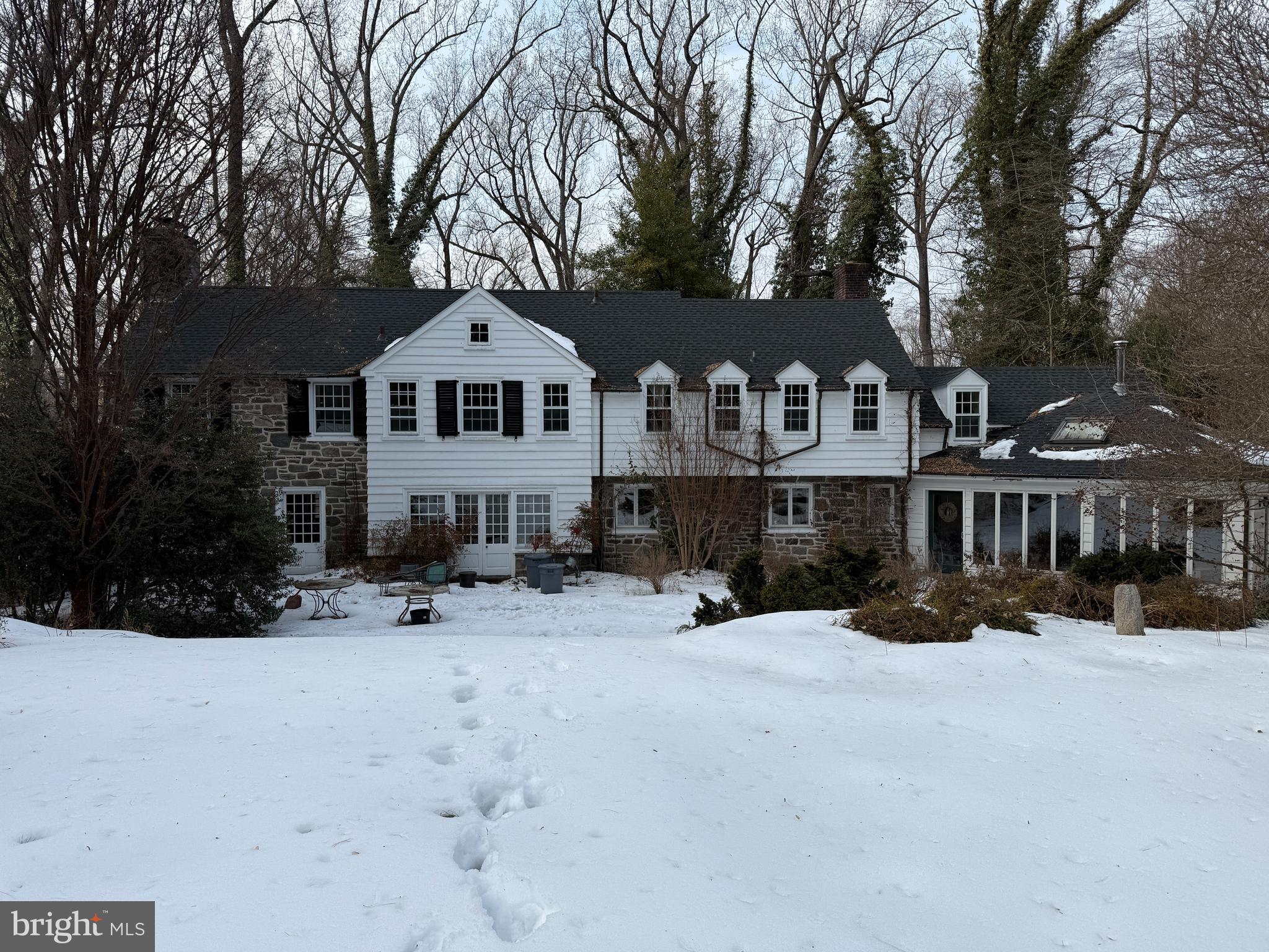 a front view of a house with a yard covered in snow