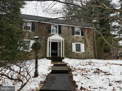 a front view of a house with a yard covered in snow