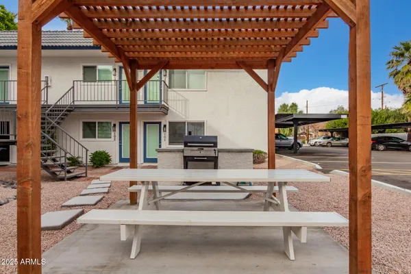 a view of a patio with table and chairs with wooden floor and fence