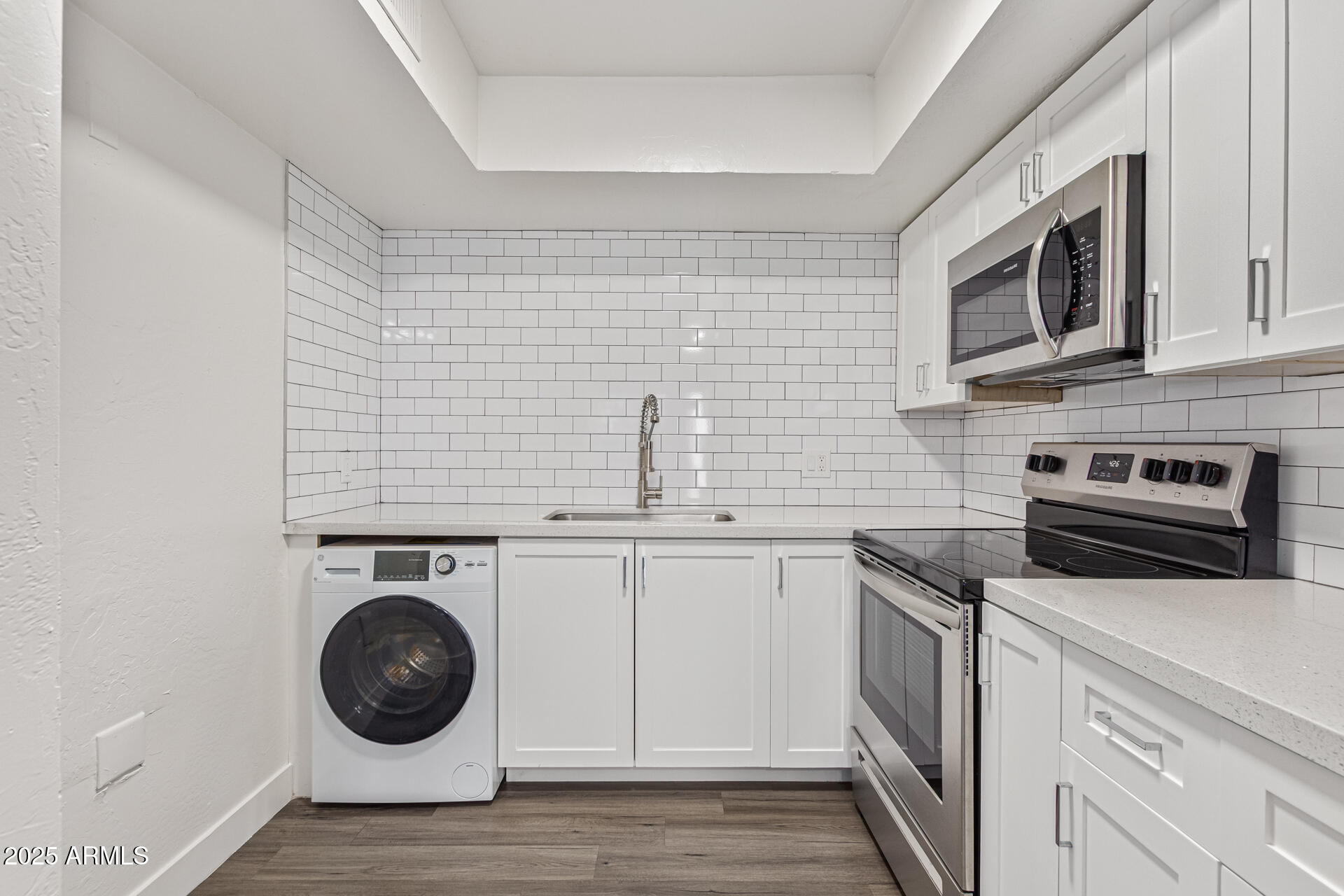 2539 North 48th Street Phoenix, AZ 85008 - Photo 15 of 26 a kitchen with cabinets stainless steel appliances and wooden floor