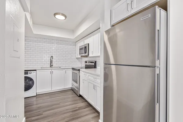 a kitchen with white cabinets and white appliances
