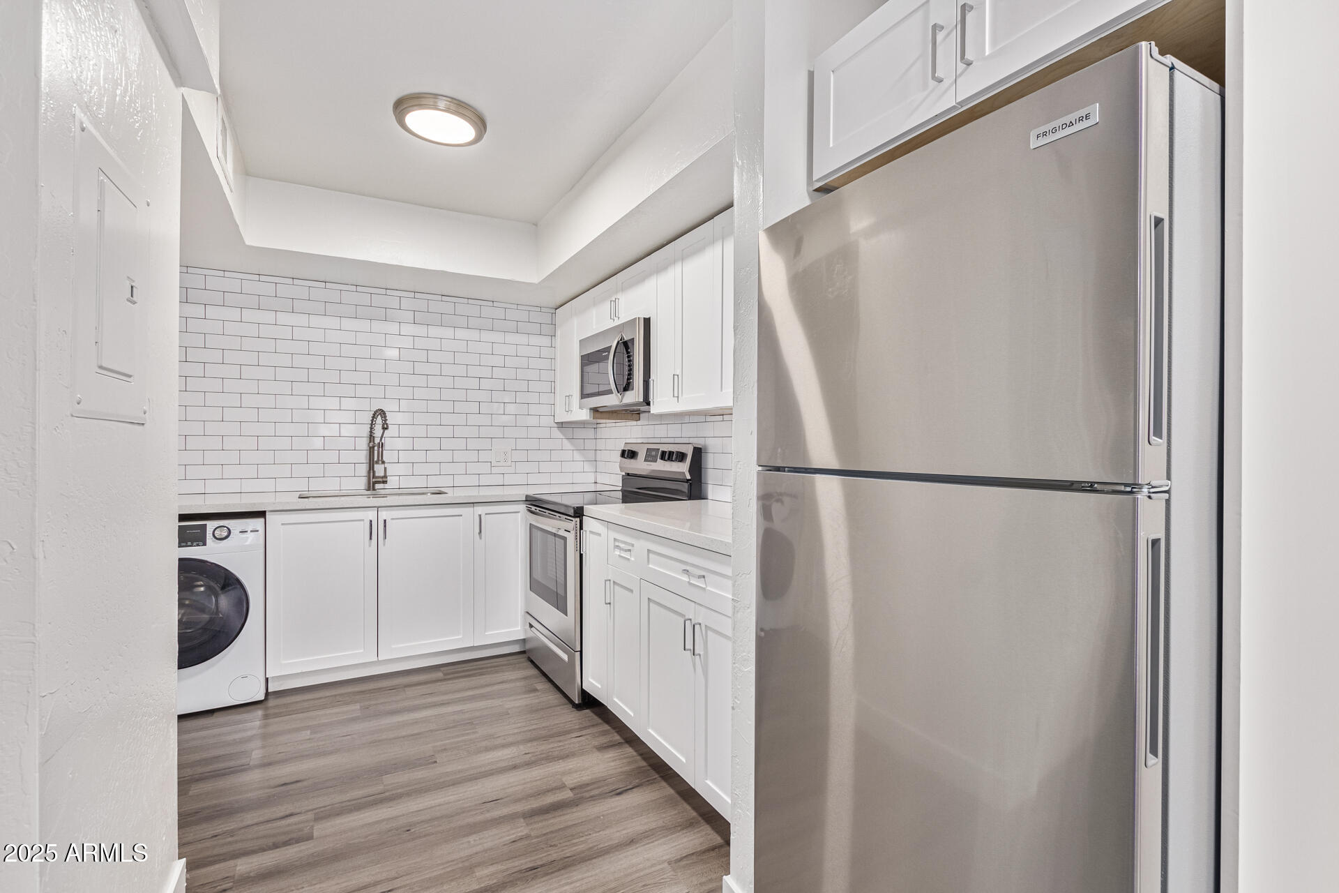 2539 North 48th Street Phoenix, AZ 85008 - Photo 17 of 26 a kitchen with white cabinets and white appliances