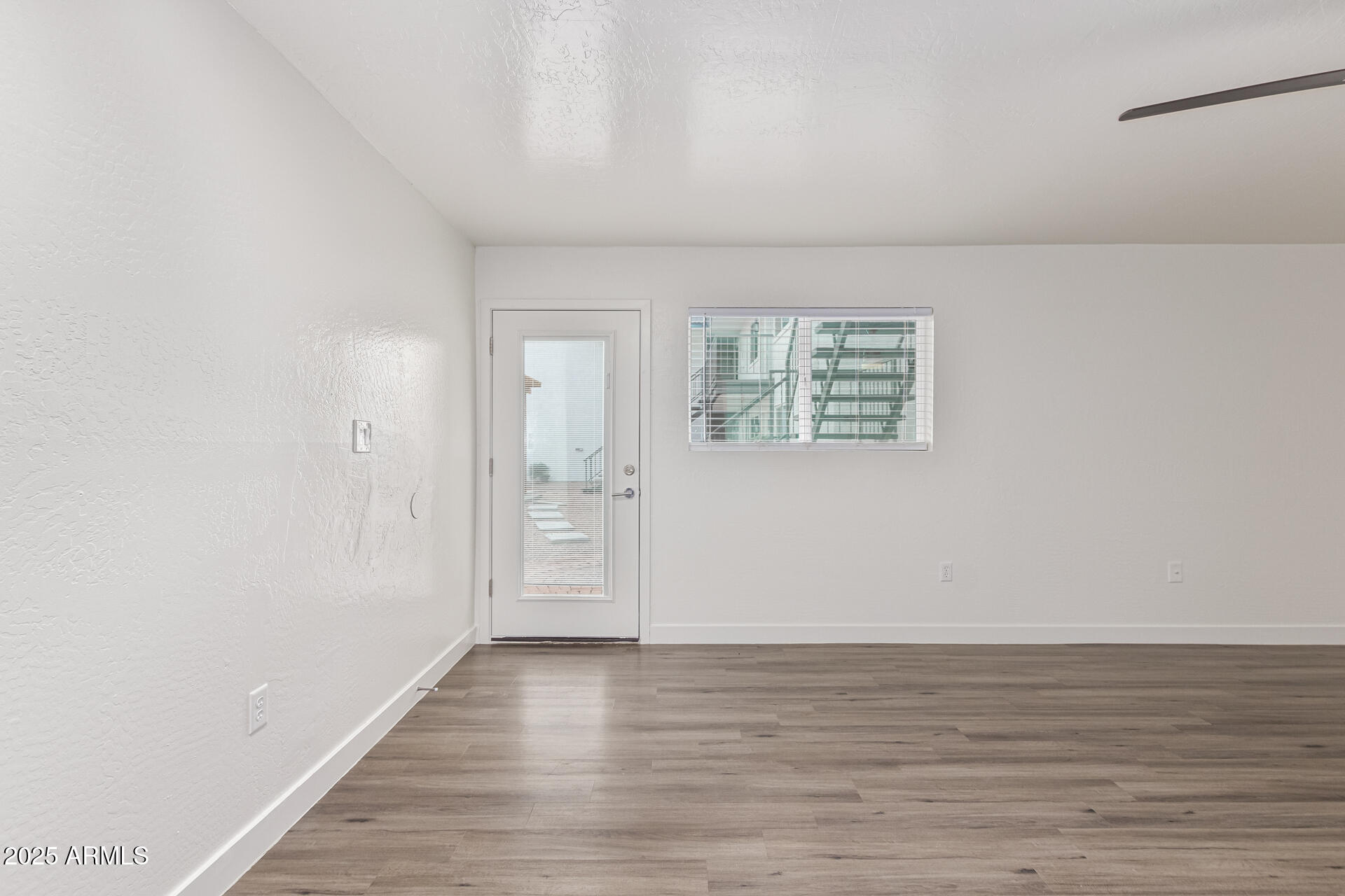 2539 North 48th Street Phoenix, AZ 85008 - Photo 18 of 26 a view of an empty room with wooden floor and a window