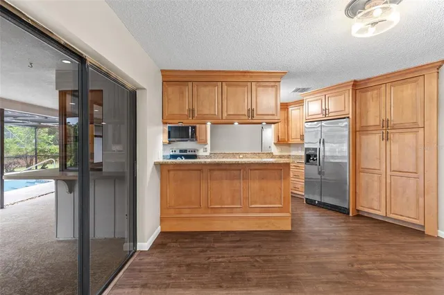 a view of an empty room with wooden floor fireplace and a window