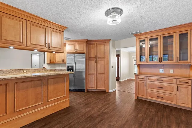 a view of an empty room with wooden floor fireplace and a window