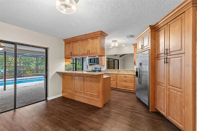 a view of an empty room with wooden floor a fireplace and a window