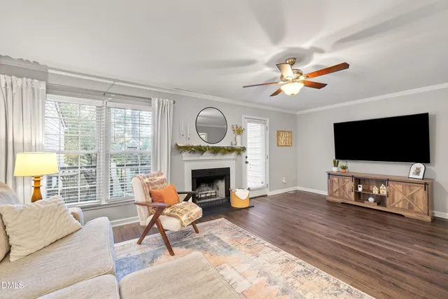 a living room with furniture a fireplace a flat screen tv and a large window