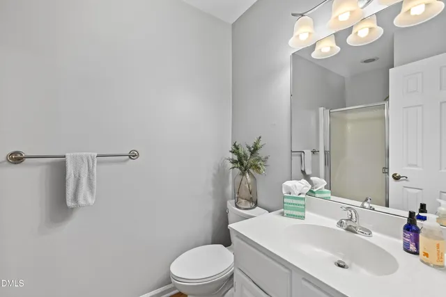 a bathroom with a sink a toilet a mirror and vanity