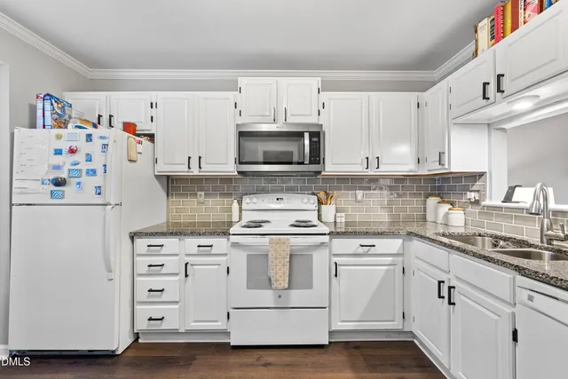 a kitchen with cabinets appliances a sink and a counter space