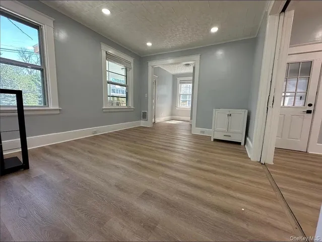 a view of a hallway with wooden floor and windows