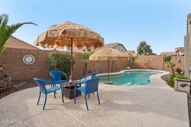 a view of a patio with table and chairs under an umbrella