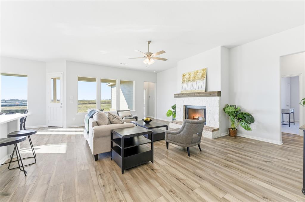 2050 County Road 200 Valley View, TX 76272 - Photo 13 of 31 Living area featuring a stone fireplace, light wood-type flooring, and ceiling fan