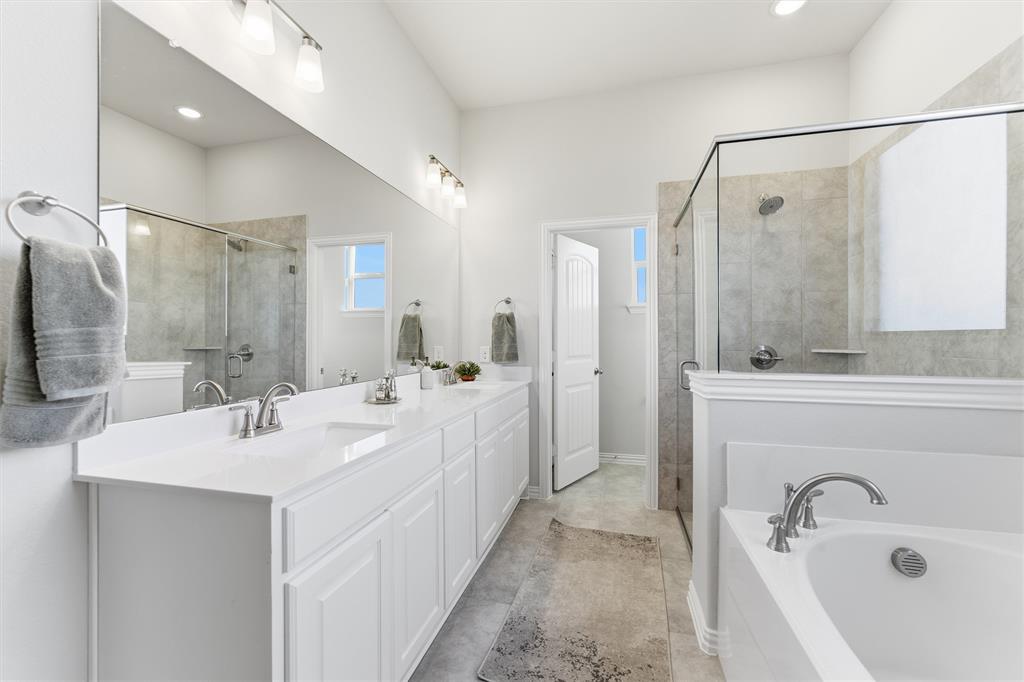 2050 County Road 200 Valley View, TX 76272 - Photo 19 of 31 Bathroom featuring double vanity, a bath, and a shower stall