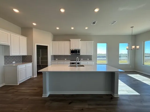 a large kitchen with kitchen island a sink stainless steel appliances and cabinets