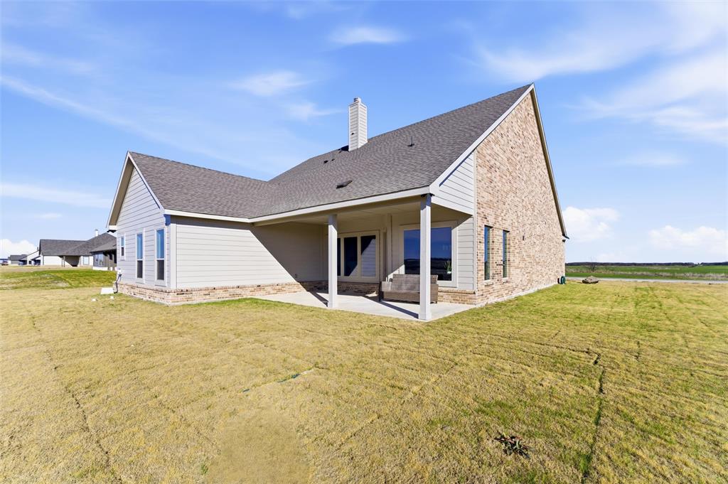 2050 County Road 200 Valley View, TX 76272 - Photo 5 of 31 Rear view of house featuring a chimney, a patio area, a lawn, and a shingled roof