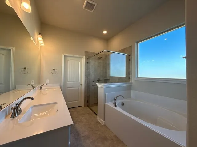 a bathroom with a tub sink and mirror