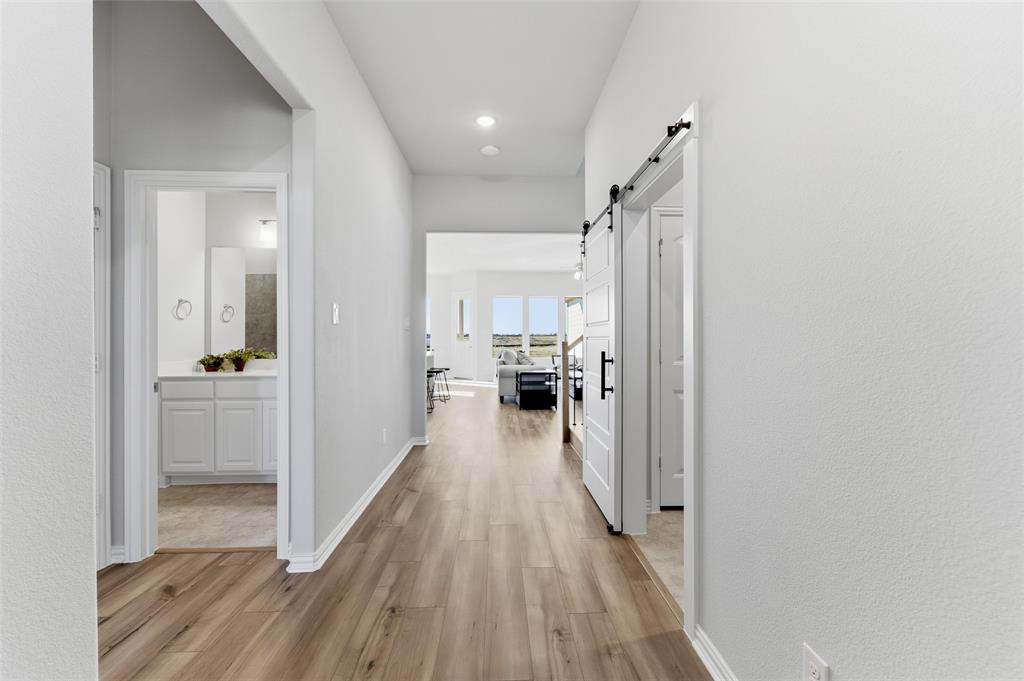 2050 County Road 200 Valley View, TX 76272 - Photo 7 of 31 Hall with light wood-style floors, a barn door, and recessed lighting