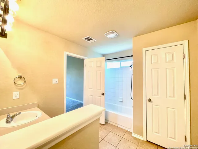 a bathroom with a tub sink and mirror