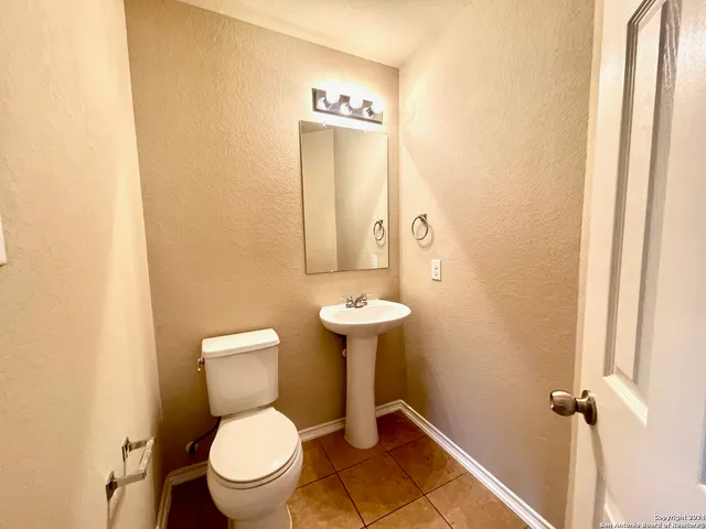 a bathroom with a toilet sink and mirror