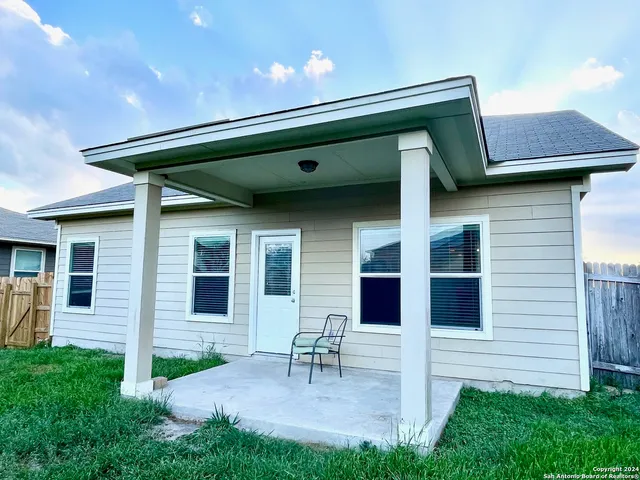 a backyard of a house with table and chairs