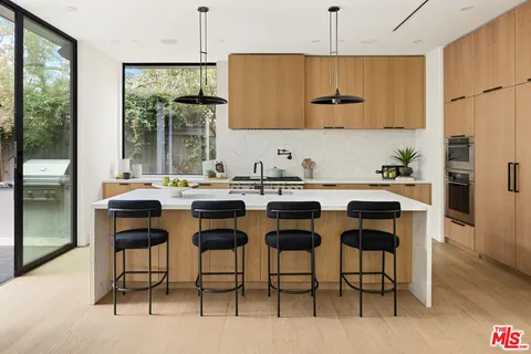 a kitchen with a dining table chairs and refrigerator