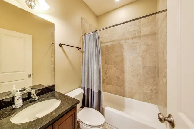 a bathroom with a granite countertop sink toilet and shower