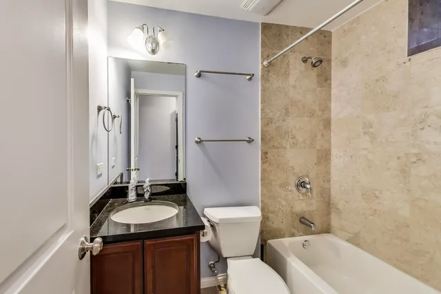 a bathroom with a granite countertop sink toilet a mirror and shower