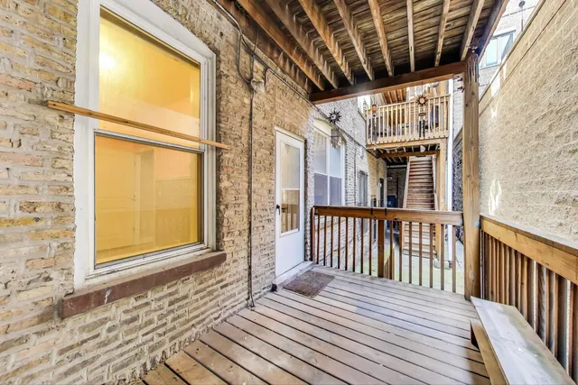 a view of a balcony with wooden floor and fence