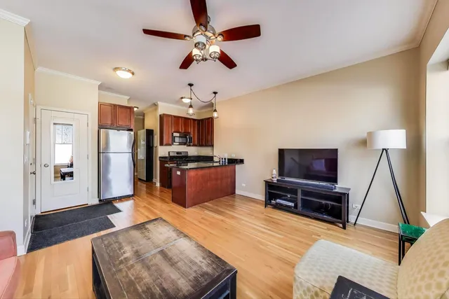 a large living room with stainless steel appliances kitchen island granite countertop furniture and a flat screen tv