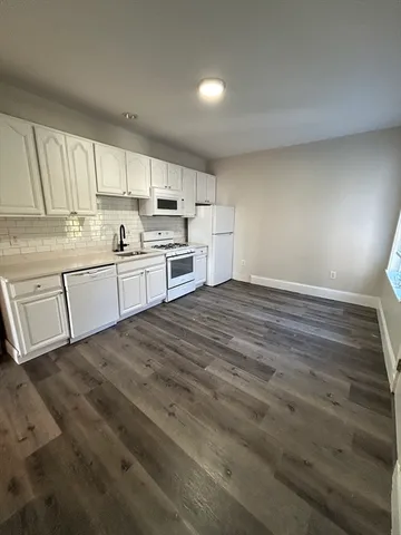 a large kitchen with a stove a sink dishwasher and a refrigerator