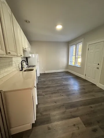a kitchen with granite countertop a sink and a refrigerator