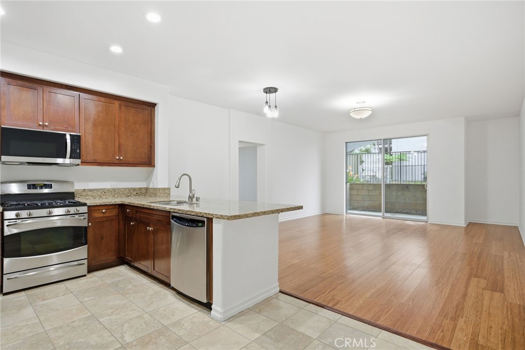 629 Traction Avenue, Unit 257 Los Angeles, CA 90013 - Photo 3 of 38 a kitchen with stainless steel appliances granite countertop a stove a sink and a microwave