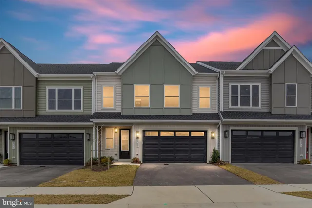 a front view of a house with yard and parking