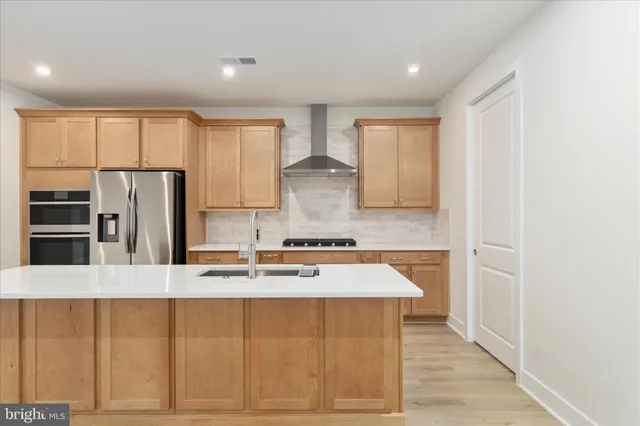 a kitchen with stainless steel appliances granite countertop a stove a sink and a refrigerator