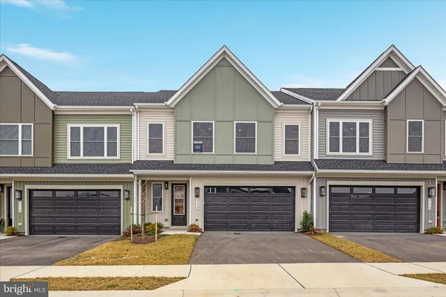 a front view of a house with yard and parking