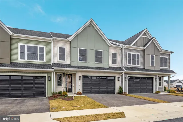 a front view of a house with yard and parking
