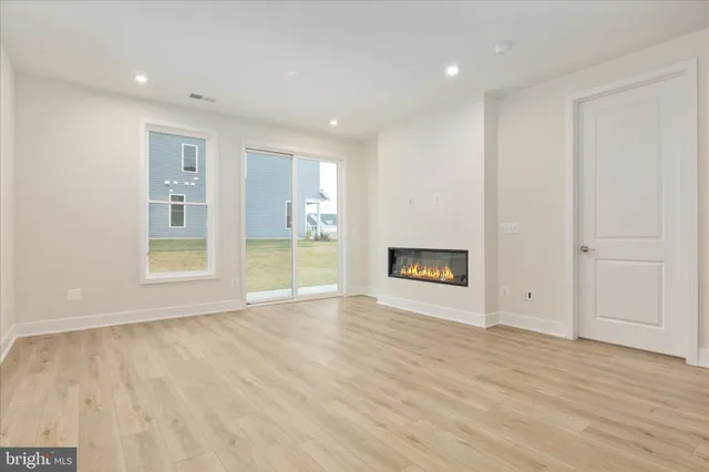 a view of an empty room with a window and a fireplace