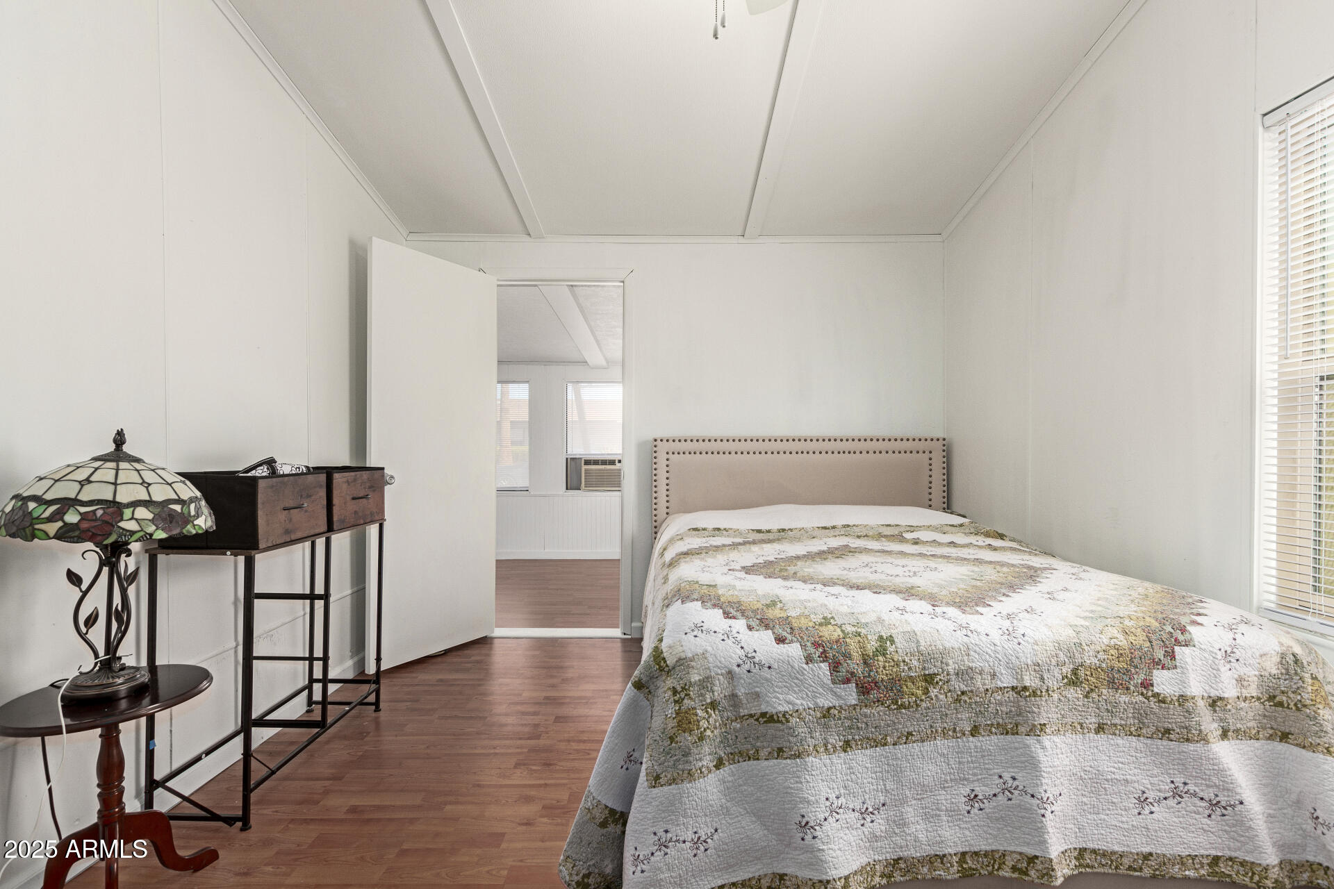 5735 East McDowell Road, Unit 213 Mesa, AZ 85215 - Photo 13 of 18 a bedroom with a bed and wooden floor