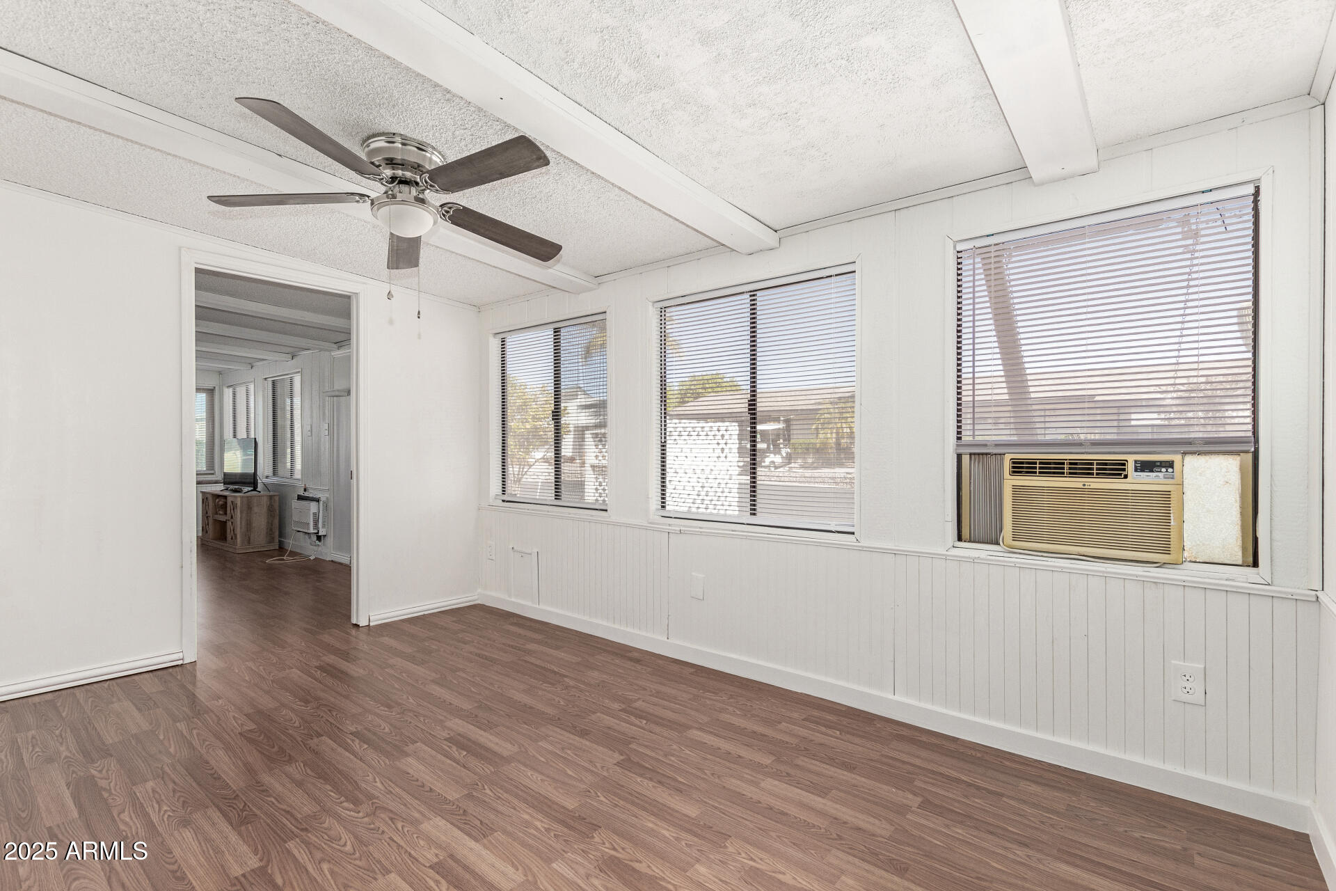 5735 East McDowell Road, Unit 213 Mesa, AZ 85215 - Photo 17 of 18 a view of an empty room with wooden floor and a window