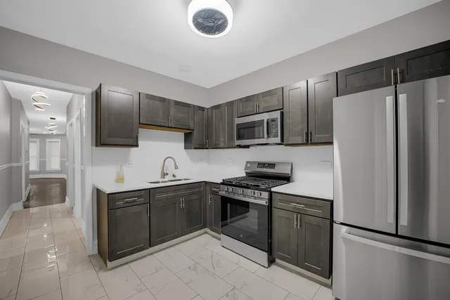 a kitchen with stainless steel appliances granite countertop a refrigerator stove a sink and dishwasher