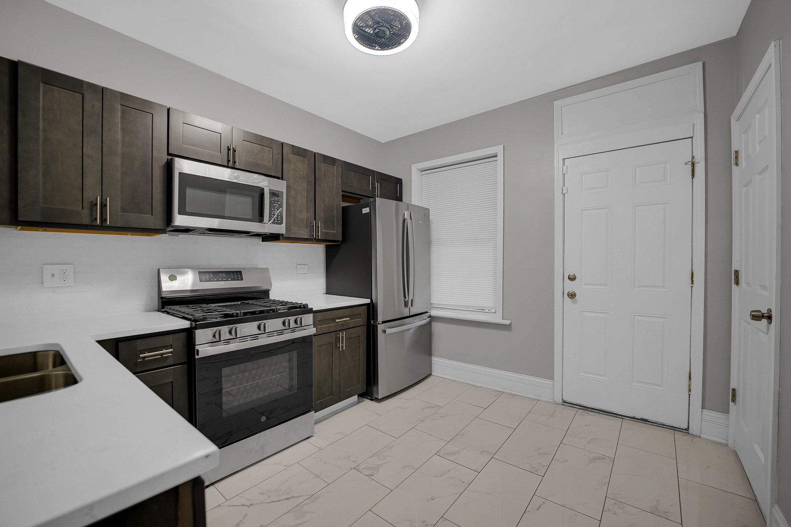 7621 South Normal Avenue Chicago, IL 60620 - Photo 13 of 32 a kitchen with granite countertop a stove and a refrigerator